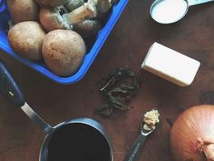 an assortment of food including mushrooms, cheese and other items on a wooden table with utensils