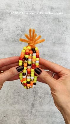 two hands holding candy corn shaped like a pineapple and an orange, yellow, green, and black pinwheel