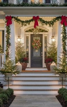 the front porch is decorated for christmas with wreaths and garland on the door steps