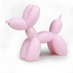 a pink balloon dog sitting on top of a white floor