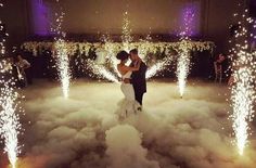 a bride and groom are dancing on the dance floor with sparklers in the background