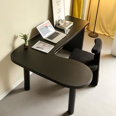 a desk with a laptop on it next to a chair