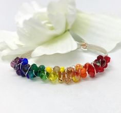 LGBTQIA+ Pride Bracelet, Beaded Bracelet, Gay Pride Bracelet, Silver Bracelet,  Wire-Wrapped Bracelet, Rainbow Bracelet  Beautiful, colorful, eclectic, beaded, wire-wrapped bracelet.   Various sizes and shapes of beads wrapped around either a  silver plated wire-wrapped bracelet. Wire is high quality non tarnish silver plated wire. Red, orange, yellow, green, blue, indigo and violet. The perfect colors of the rainbow -ROYGBIV!   Dress it up or down, mix it up with others or wear it alone.  This is the perfect bracelet for any outfit.   These are custom made at the time of purchase. Specify the length needed when you place your order.  Each one of these bracelets is individually made by me. The beads in each will be slightly different than what is pictured but equally as beautiful. Gay Pride Bracelet, Colorful Eclectic, Lgbtqia Pride, Bracelet Rainbow, Pride Bracelet, Tarnished Silver, Wire Wrapped Bracelet, Rainbow Bracelet, Beaded Wraps