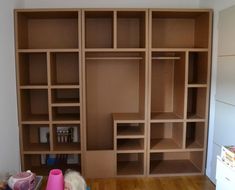 an empty room with shelves and toys on the floor