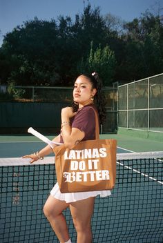 a woman holding a brown bag with the words latinas do it better on it