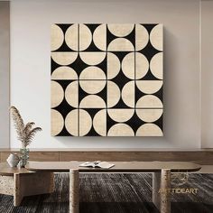 an abstract art piece hangs on the wall above a coffee table in a modern living room