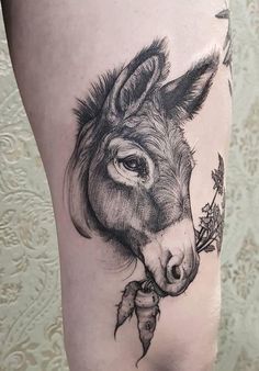 a close up of a person's leg with a donkey tattoo on the thigh