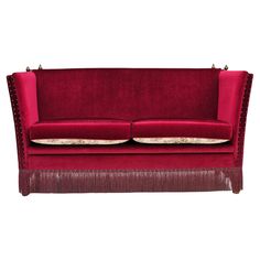 a red couch with two pillows on it's back and the seat upholstered