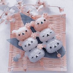 four teddy bears sitting on top of each other in a wicker basket next to flowers