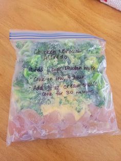 a bag filled with broccoli sitting on top of a wooden table