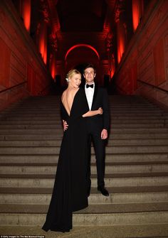 a man and woman in formal wear standing on stairs