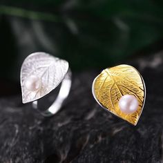 Introducing our exquisite Pearl Leaf Ring, a captivating piece that combines nature-inspired design with luxurious elegance. The ring features a beautifully detailed leaf crafted from high-quality 925 sterling silver, intricately plated with gold to highlight the delicate veins and texture of the leaf. Atop the golden leaf rests a lustrous pearl, adding a touch of classic sophistication and a luminous glow. The contrast between the shimmering silver band, the rich gold leaf, and the radiant pear Leaf Rings, Natural Pearl Jewelry, Gold Leaf Rings, Motifs Perler, Leaf Jewelry, Leaf Ring, Handmade Rings, Exclusive Jewelry, Natural Pearl