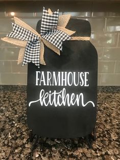 a chalkboard sign that says farmhouse kitchen with a bow on the front and bottom