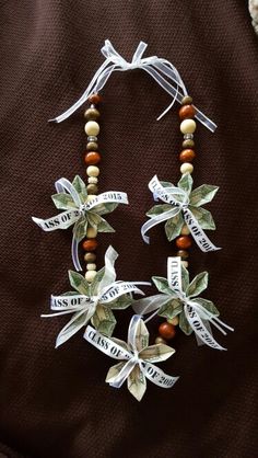 a necklace made out of wood beads and ribbon with words written on the side,