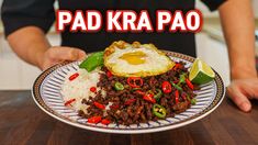 a person holding a plate with food on it that says pad kra pao