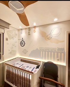 a baby's room with a crib and wall mural