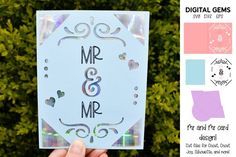 a hand holding up a card with the word mr and mrs on it in front of some bushes