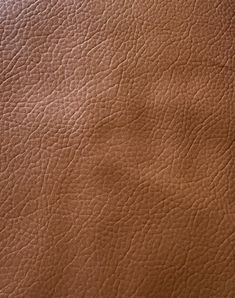 the texture of a brown leather material is shown in close - up view, as if it were from an airplane or plane