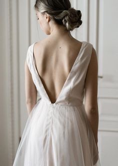 the back of a woman's wedding dress, with her hair in a bun