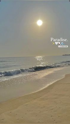 the sun is shining over the ocean and beach with footprints in the sand on the shore