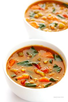 two bowls of vegetable soup on a white surface