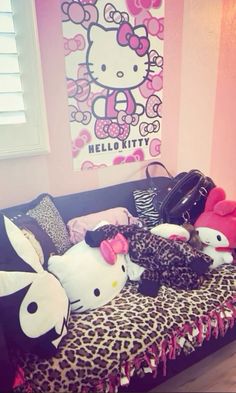 hello kitty stuffed animals are sitting on a leopard print couch in front of a hello kitty poster