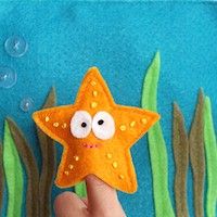 a hand holding up a starfish with bubbles in the background