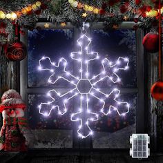 a lighted snowflake in front of a window