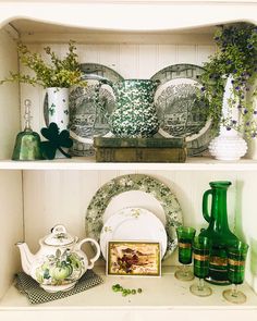 two shelves filled with vases, plates and other items