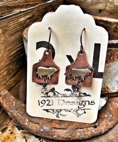 the earrings are made out of wood and have metal hooks on them, with an old rust