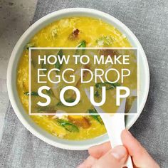 someone holding a spoon over a bowl of egg drop soup with the words how to make egg drop soup