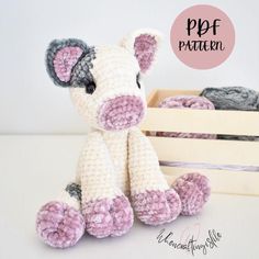 a crocheted stuffed animal sitting next to a wooden crate