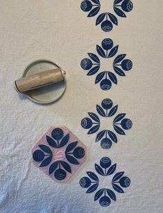 a white table cloth with blue and pink designs on it next to a pair of scissors