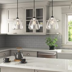 a kitchen with gray cabinets and white counter tops