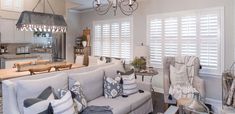 a living room filled with furniture and a chandelier hanging over the top of it