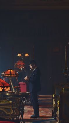 a man in a suit standing next to a table