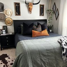 a bed room with a neatly made bed and two deer head mounted on the wall