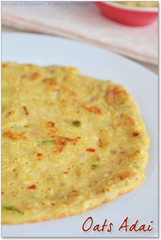 an omelet is sitting on a white plate with the words oats ajai written below it