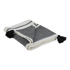 a black and white striped towel with tassels on it's edges, folded up