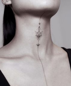 a woman's neck with a flower tattoo on the back of her left side