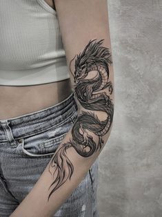 a woman with a dragon tattoo on her arm