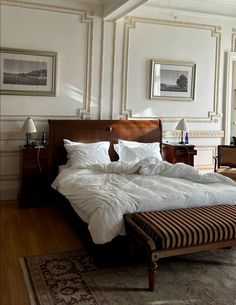 a large bed sitting in the middle of a bedroom next to a desk and chair