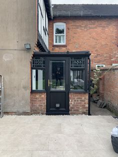 a small black door in front of a brick building