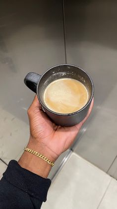 a person holding a cup of coffee in their hand