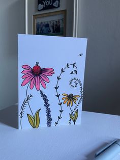 a card with flowers on it sitting on a table