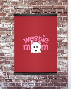 a red poster hanging on a brick wall with the words westie mom written in pink