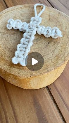 a crocheted cross sitting on top of a wooden bowl