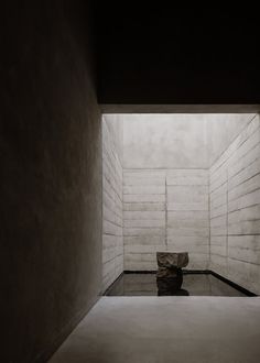 an empty room with a bench in the center and water on the floor below it