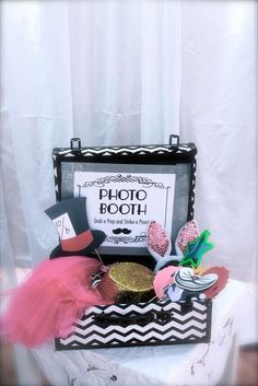 a black and white photo booth with pink tutu skirt, top hat, mustache, bow tie