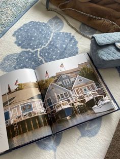 an open book sitting on top of a bed next to a purse